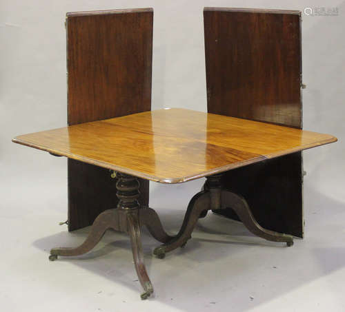 A George III mahogany twin pedestal dining table with two leaves, the moulded top raised on turned