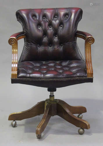 A 20th century reproduction stained beech and red leather revolving office chair, height 90cm, width