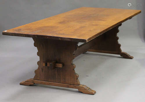 A 20th century oak refectory table, the rectangular top raised on shaped supports, united by a