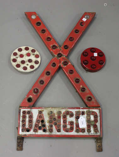 A red and white coated metal 'X' shaped 'Danger' road sign, inset with overall reflectors,