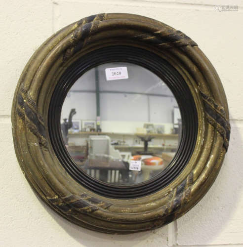 A small Regency giltwood convex wall mirror, the triple ringed frame with ebonized ribbon