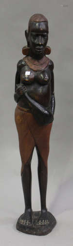 A 20th century African carved hardwood figure of a woman holding a gourd, height 95cm.Buyer’s