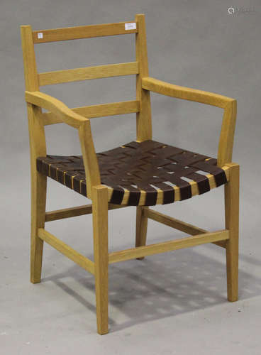 A late 20th century oak framed elbow chair, possibly by Heals, the leather woven seat on tapering