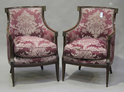 A pair of 20th century French Empire style mahogany framed armchairs, on square tapering sabre legs,