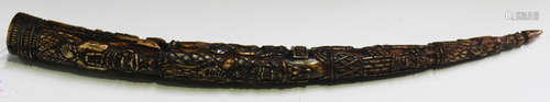 A 19th century Benin carved ivory tusk, profusely worked with bands of warriors, length 56cm.Buyer’s