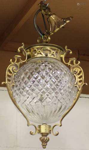 A 20th century cast gilt metal and clear glass hanging ceiling lantern with foliate scrolling