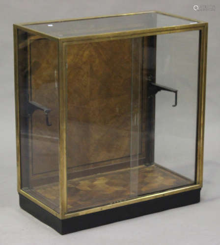 An early 20th century brass framed shop display cabinet, fitted with sliding doors above a parquetry