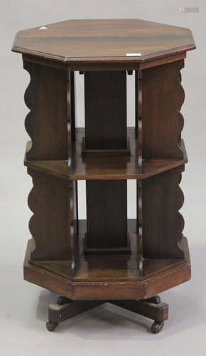 An Edwardian walnut octagonal revolving bookcase with shaped supports, raised on castors, height