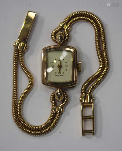 A 9ct gold curved rectangular cased lady's wristwatch with an unsigned jewelled Swiss movement,