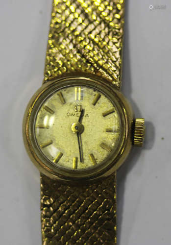 An Omega 9ct gold lady's bracelet wristwatch, the signed silvered dial with gilt baton hour markers,