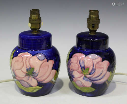 A pair of Moorcroft pottery lampbases, 1970s, each decorated with pink magnolia against a cobalt