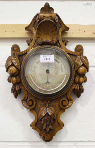 A late Victorian oak cased wall barometer, the silvered dial with alcohol thermometer and