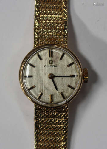 An Omega 9ct gold circular cased lady's bracelet wristwatch, the signed silvered dial with baton