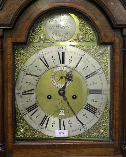 A George III oak longcase clock with eight day movement striking on a bell, the brass break arch