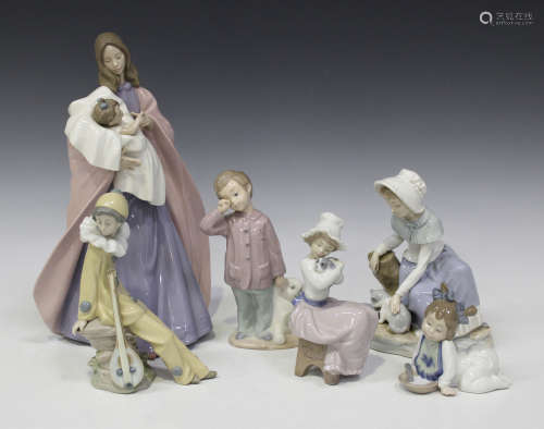 A collection of sixteen Nao porcelain figures, including a child with teddy bear, a mother and