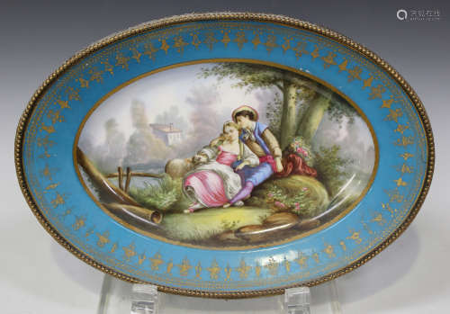 A Sèvres style porcelain oval dish with brass mounted bead border, late 19th century, the centre
