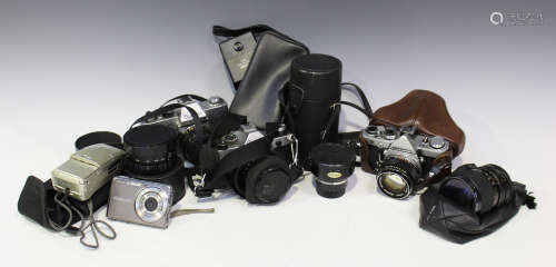 A collection of cameras and accessories, including an Olympus OM-1 camera with G. Zuiko Auto-S 1:1.4