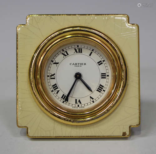 A Cartier Paris gilt metal and cream coloured lacquer cased travelling alarm clock, the signed