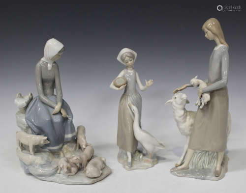 A Nao porcelain figure group of a seated girl accompanied by five piglets, height 27cm, a Lladro