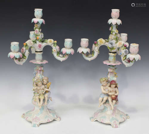 A pair of Sitzendorf porcelain allegorical four light candelabra, late 19th century, each scroll