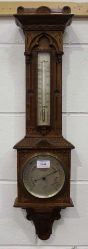A late Victorian oak cased wall barometer with mercury thermometer and silvered dials, inscribed '