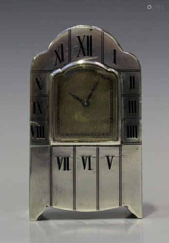 An early 20th century Continental silver cased miniature bedside timepiece, the arched dial framed