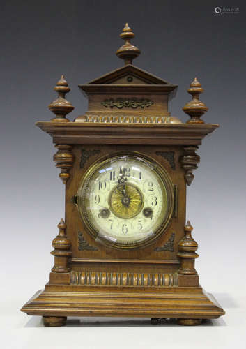 A late 19th century German walnut mantel clock with eight day movement striking on a gong, the