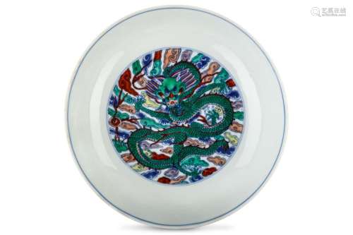 A CHINESE DOUCAI ‘DRAGON’ BOWL. Kangxi mark and of the period. The interior with a roundel enclosing a coiled five-clawed dragon facing forwards with a fearsome expression, beside a flaming pearl, among multi-coloured clouds, the exterior with a