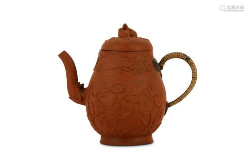 A CHINESE YIXING ZISHA TEAPOT AND COVER. Kangxi. The rounded body supported on a splayed foot, and surmounted by a domed cover with a finial formed as a well modelled squirrel, the body moulded with flowering plants below a band of floral spray, the