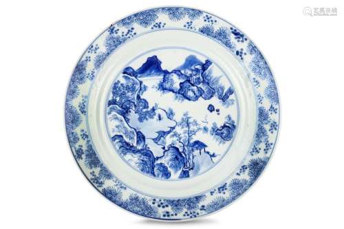 A CHINESE BLUE AND WHITE ‘MASTER OF THE ROCKS’ DISH. Kangxi. Painted to the interior in the 'Master of the Rocks' style with figures in a mountainous river landscape, below a band of pine boughs at the rim, the exterior is decorated with two