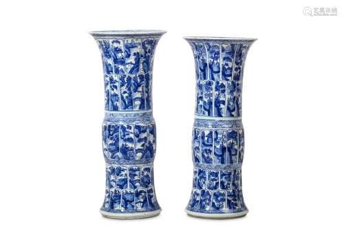 A PAIR OF CHINESE BLUE AND WHITE 'LANDSCAPE' MOULDED BEAKER VASES, GU. Kangxi. Of cylindrical form with a flaring mouth and foot, each divided into bands of lappets each enclosing a landscape scene, 42cm H, 18cm diameter. (2) 清康熙   青花山水圖觚式瓶一對
