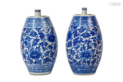 A PAIR OF CHINESE BLUE AND WHITE SPIRIT BOTTLES. Kangxi. Each of barrel shape, the top with a short cylindrical spout, decorated all over with scrolling chrysanthemum and foliage, 14cm H. (2) Provenance: English private collection, acquired from