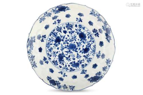 A CHINESE BLUE AND WHITE 'FLOWERS' MOULDED DISH. Kangxi mark and of the period. Decorated with a central floral roundel, surrounded by a moulded lappet band enclosing further flowers below a foliate rim, six character Kangxi mark to base, 19cm