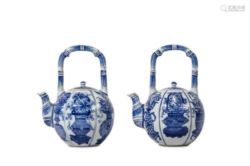 A PAIR OF CHINESE BLUE AND WHITE ‘FLOWER BASKET’ TEAPOTS AND COVERS. Kangxi. Each painted to the globular body with six panels of flowers each in a different vase, the handle and spout in simulation of bamboo, 16cm H. (4) Provenance: English