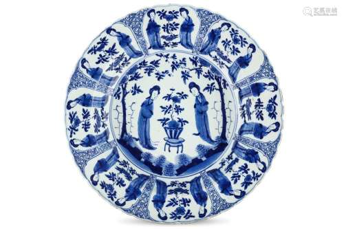 A CHINESE BLUE AND WHITE ‘LADIES’ BASIN DISH. Kangxi mark and of the period. The deep bowl with a central roundel enclosing ladies separated by a flowering plum tree on a stand, enclosed within a band of panels enclosing the repeated motif, six