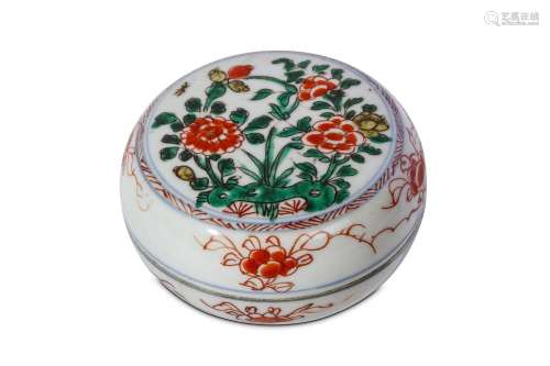 A CHINESE FAMILLE VERTE 'PEONIES' CIRCULAR BOX AND COVER. Kangxi. The cover enamelled with a roundel of flowers emerging from behind a rock, the sides of the base and cover enamelled in iron red with a band of flower heads, 12cm diameter. (2)