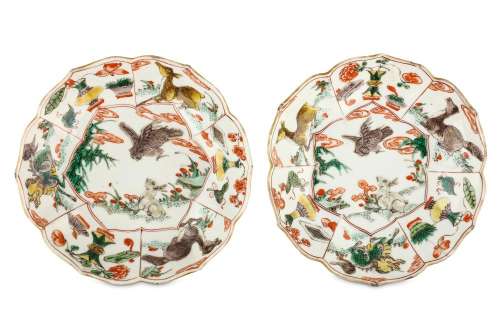 A PAIR OF CHINESE FAMILLE VERTE FOLIATE RIM 'RABBIT AND HAWK' SAUCER DISHES. Kangxi. Each decorated with a central roundel of a rabbit beside lingzhi fungus confronting a hawk in flight, within a border of six moulded panels alternating with antiques