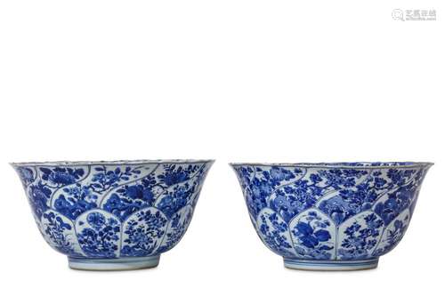 A PAIR OF CHINESE LARGE MOULDED BLUE AND WHITE BOWLS. Kangxi. Each with deep rounded sides rising from a short foot to an everted foliate rim, moulded and painted around the body with flower-filled lotus lappets below flower-filled spiralling panels,