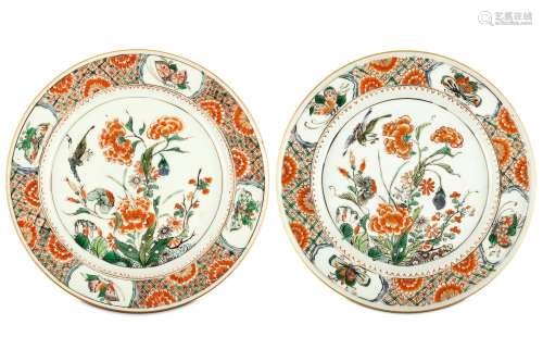 A PAIR OF CHINESE FAMILLE VERTE ‘BIRD AND FLOWER’ DISHES. Kangxi. The central roundel finely enamelled with peonies and other flowering plants with an attendant bird, within a diaper border interspersed with flower heads and with four panels