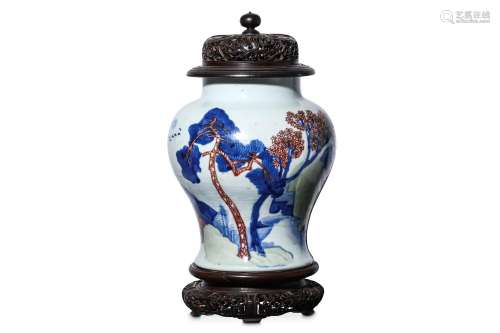 A CHINESE UNDERGLAZE BLUE COPPER-RED AND CELADON-GLAZED ‘LANDSCAPE’ VASE. Kangxi. Of baluster form, painted and modelled in relief to depict a watery landscape filled with rocks and trees, wood cover and stand, 26cm H. (3) 清康熙