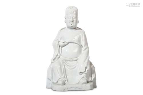 A CHINESE BLANC DE CHINE SEATED FIGURE. Early Qing. Seated in flowing robes, the left arm obscured below long sleeves the right hand supporting a belt, 25cm H. 清早期   德化窯官員坐像