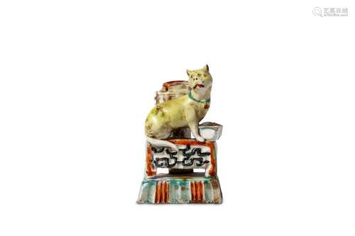 A CHINESE GLAZED DEHUA 'CAT' JOSS STICK HOLDER. 18th Century. The cat seated on a rectangular base beside a bowl, the head tilted to the right with a forlorn look on the face, 7cm H. 清十八世紀   德化窯加彩貓型香插