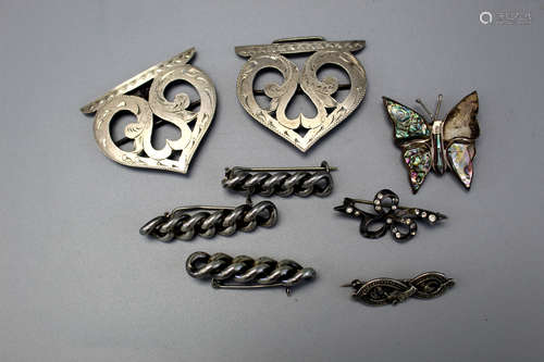 Eight sterling silver brooches.