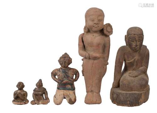 A Thai carved wood Buddha and four pottery fertility figures