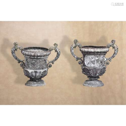 A pair of Victorian cast lead twin handled urns in Baroque style