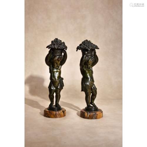 A pair of patinated bronze and marmo convento Siena mounted models of putti