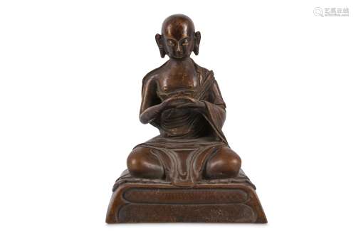 A BRONZE SEATED FIGURE. Seated in loosely fitting