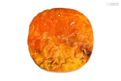 A CHINESE AMBER ‘LOTUS SCROLL’ OVAL PANEL.