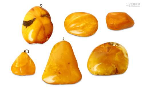 A COLLECTION OF AMBER PENDANTS AND BROACHES. 3-5cm