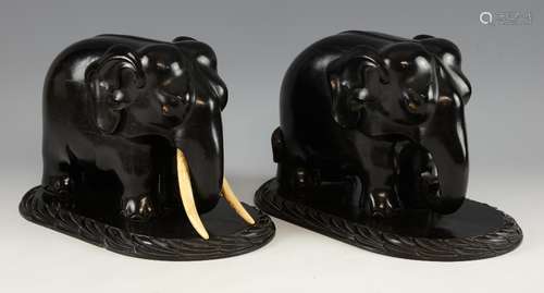 Pair of 19th century carved ebony elephants with ivory tusks and eyes on integral oval carved bases,